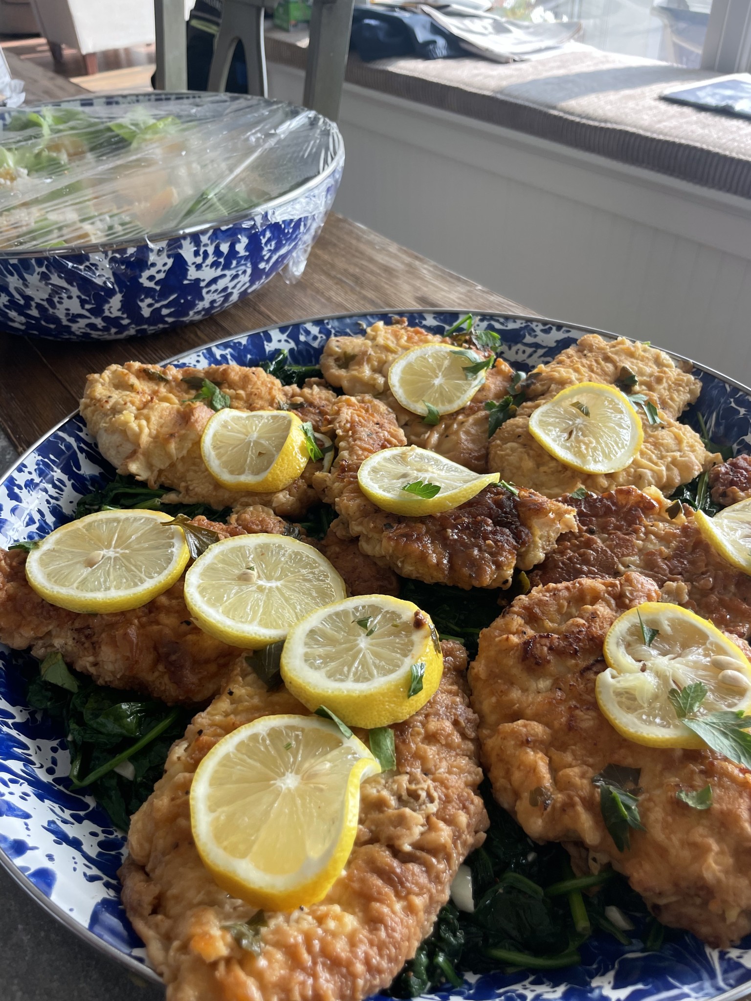Lemon chicken arranged on a blue and white platter